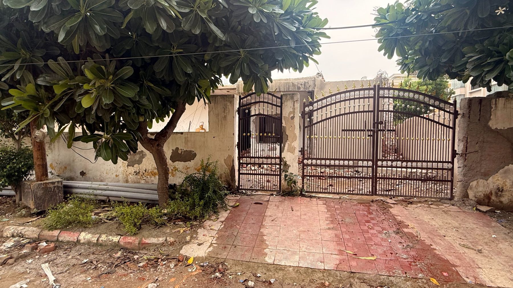 Gated frontage of the plot in Ashram Vihar, Vrindavan, with a paved entrance
